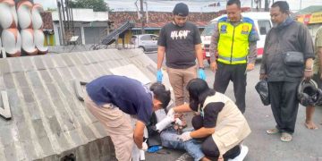 Petugas dan tenaga medis menangani pengendara Honda Vario yang terluka setelah terlibat kecelakaan dengan ambulans pembawa jenazah di Simpang Karangnongko, Wates, Kulon Progo, Sabtu (30/5/2026). Korban mengalami patah jari kelingking tangan kanan serta lecet pada tangan dan kaki. (Foto: Istimewa)