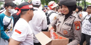 Polisi Distribusikan Air Mineral dan Roti kepada Demonstran di Depan Gedung DPR