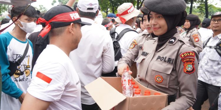 Polisi Distribusikan Air Mineral dan Roti kepada Demonstran di Depan Gedung DPR