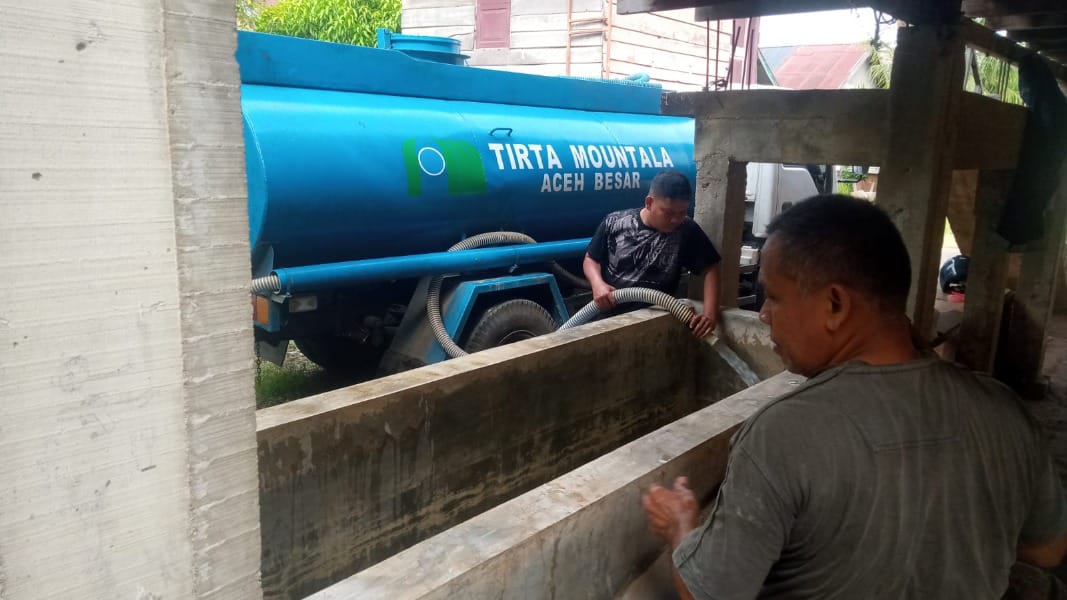 : Petugas Perumdam Tirta Mountala Aceh Besar menyalurkan air bersih menggunakan mobil tangki kepada warga terdampak kekeringan di Kabupaten Aceh Besar, Selasa (4/8/2026). Selama sepekan terakhir, Perumdam Tirta Mountala telah mendistribusikan sekitar 270 ribu liter air bersih ke sejumlah wilayah yang mengalami krisis air.