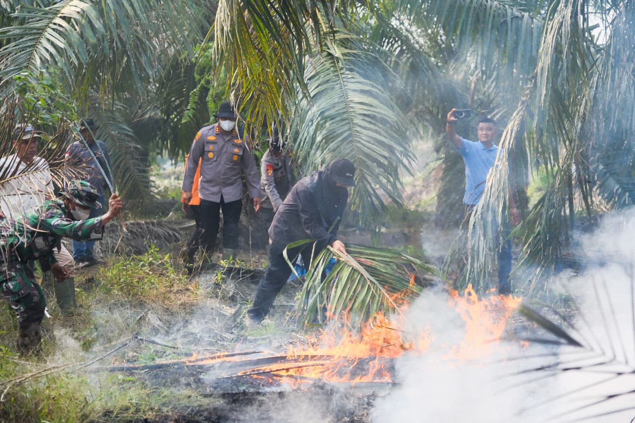 : Bupati Siak Afni Zulkifli dan Kapolres Siak bersama tim satgas karhutla membantu memadamkan api, pada Minggu (30/8/2026)/ (MC Siak).