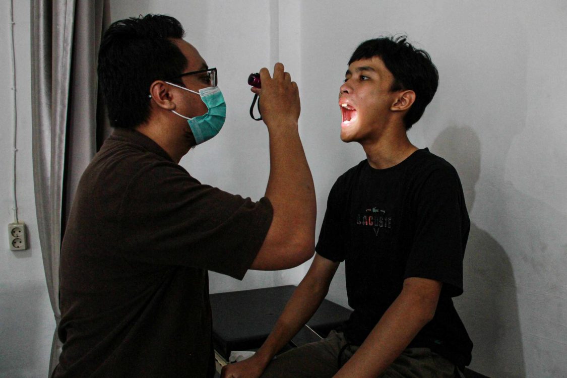 : Dokter memeriksa peradangan tenggorokan pasien bergejala Infeksi Saluran Pernapasan Akut (ISPA) di Puskesmas Bukit Hindu, Palangka Raya, Kalimantan Tengah, Jumat (21/8/2026). Dinas Kesehatan Kota Palangka Raya menyiapkan layanan ruang oksigen di 11 Puskesmas di Palangka Raya untuk warga yang mengalami gejala Infeksi Saluran Pernapasan Akut (ISPA) akibat kabut asap kebakaran hutan dan lahan, dimana kasus ISPA di Palangka Raya mengalami peningkatan dari 1.849 pada Juni 2026 menjadi 2.293 pada Juli 2026, dan data sementara 20 Agustus 2026 sebanyak 1.899 kasus. (ANTARA FOTO/Auliya Rahman/YU)