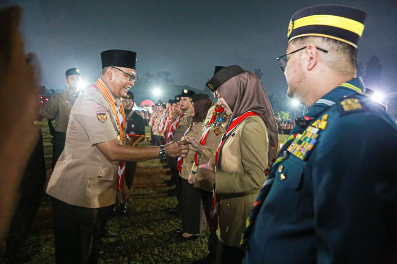 : Ketua Kwarnas Gerakan Purn) Drs. Budi Waseso menyematkan tanda penghargaan Gerakan Pramuka Lencana Darma Bakti kepada Ketua Kwarcab Kota Pekanbaru Kak Sulastri A., pada Upacara Ulang Janji Peringatan Hari Pramuka ke-65 Tingkat Nasional. -Foto: Mc.Pekanbaru