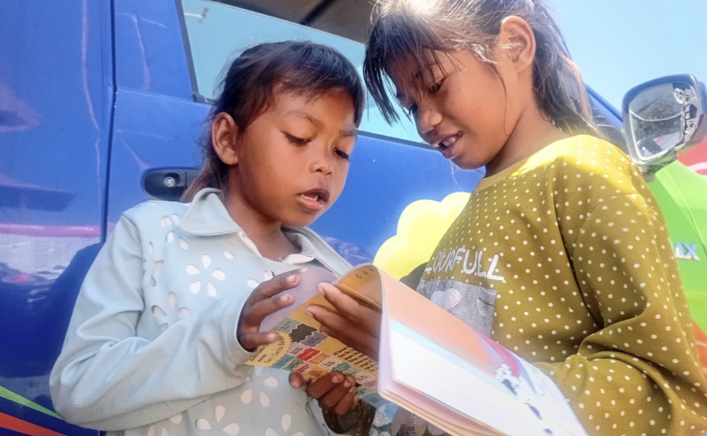 : Anak- anak sedang membaca buku perpustakaan keliling di pengungsian GOR Samador, Kabupaten Sikka, Nusa Tenggara Timur, Selasa (18/8/2026). (Dok. Pusdatinkom BNPB)