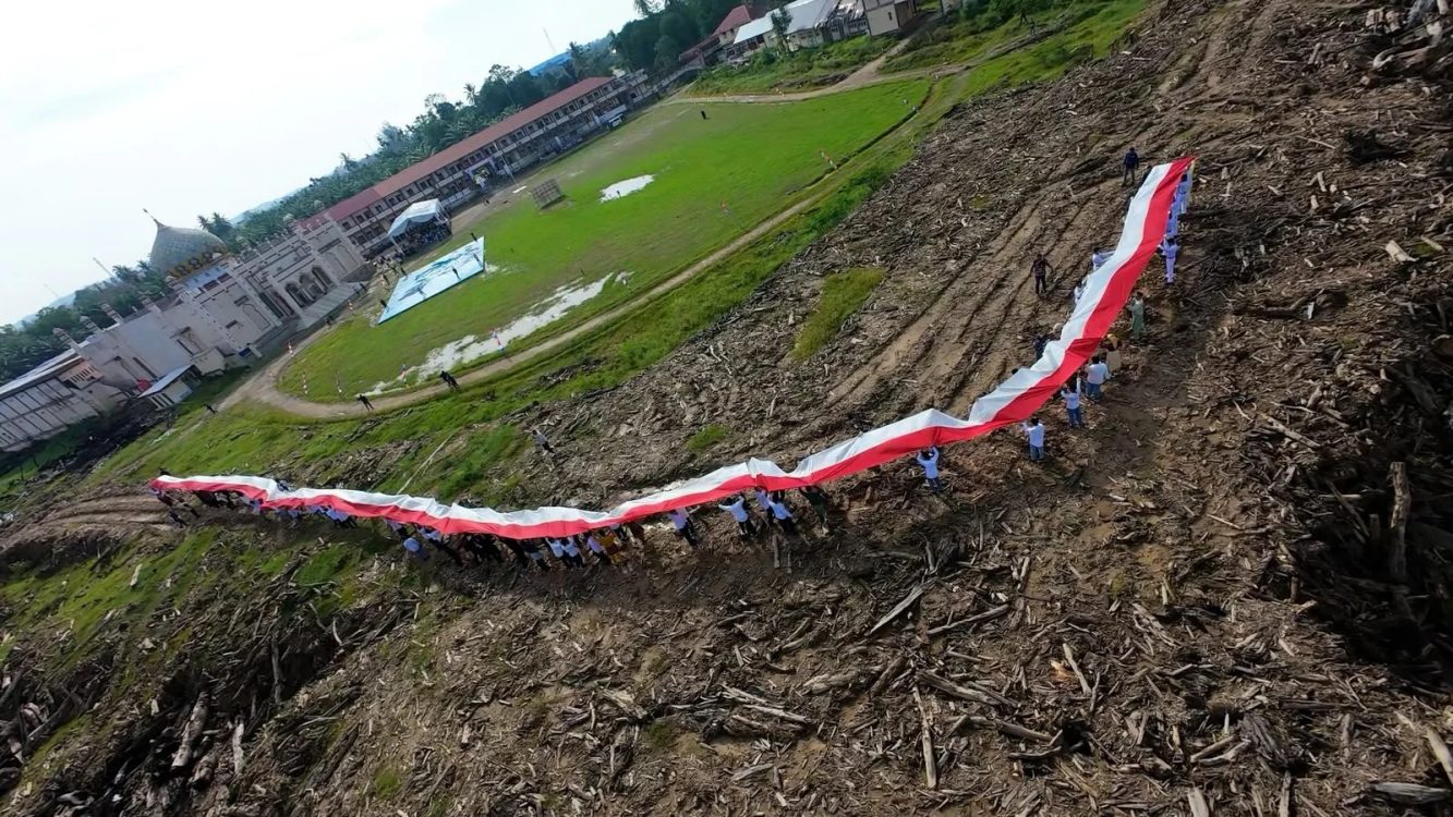 : Relawan, santri, dan masyarakat membentangkan bendera Merah Putih sepanjang 81 meter dalam rangka memperingati HUT ke-81 Kemerdekaan RI di Pondok Pesantren Darul Mukhlisin, Aceh Tamiang, Senin (17/8/2026). Kegiatan ini menjadi simbol persatuan dan semangat bangkit masyarakat Aceh Tamiang.