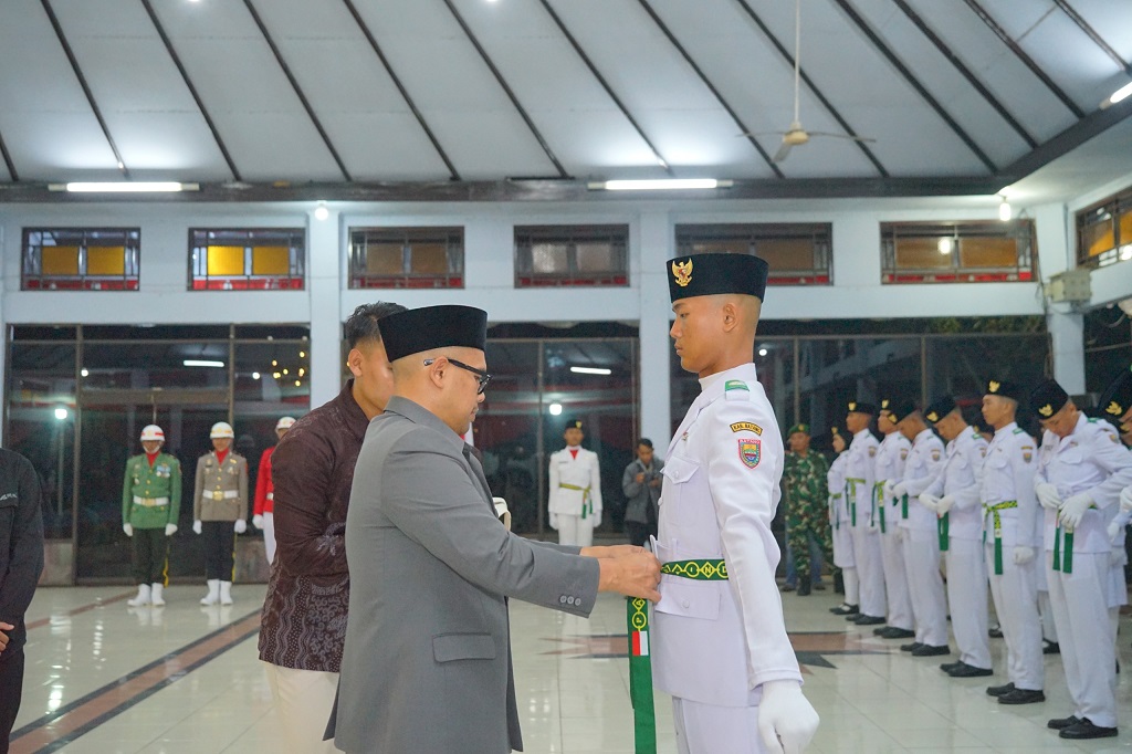 : Bupati Batang M. Faiz Kurniawan secara simbolis memasang tali kendit saat pengukuhan Paskibraka di Pendopo Kabupaten Batang.