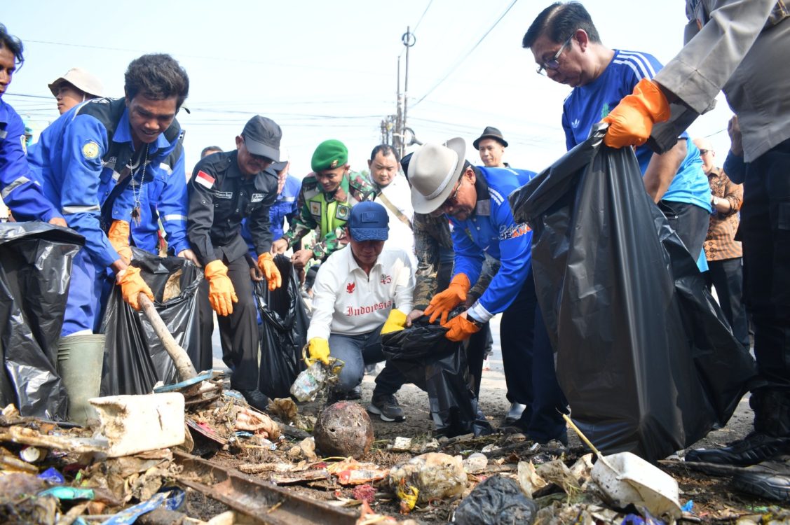 : (Dari kiri) Pj. Sekda Kabupaten Indramayu Aan Hendrajana, Wakil Menteri Koordinator Bidang Pangan RI Hanif Faisol Nurofiq, dan Camat Jatibarang Mardono, memungut sampah saat mengikuti aksi bersih-bersih di kawasan Sungai Sindupraja, Jalan Raya Jatibarang, Kabupaten Indramayu, Kamis (20/8/2026). Aksi gotong royong tersebut merupakan tindak lanjut dari arahan Presiden RI Prabowo Subianto untuk membangun kebiasaan korve atau bersih-bersih lingkungan sebelum memulai aktivitas kedinasan.
