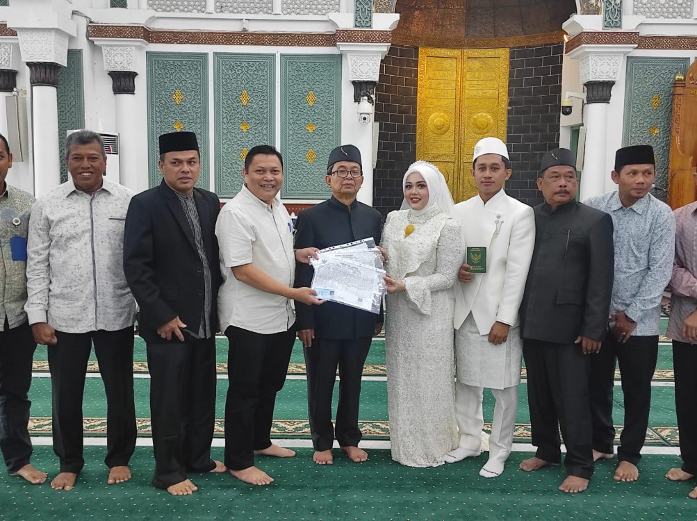 : Kepala Dinas Kependudukan dan Pencatatan Sipil (Disdukcapil) Kota Banda Aceh, Heru Triwijanarko, menyerahkan Kartu Keluarga (KK) baru serta Kartu Tanda Penduduk (KTP) elektronik yang telah diperbarui dengan status perkawinan menjadi “Kawin tercatat” kepada pasangan tersebut.