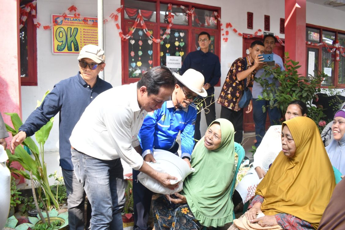 : Wamenko Bidang Pangan (kiri) menyerahkan bantuan sosial berupa beras 30kg kepada warga di Desa Lobener Lor, Kecamatan Jatibarang, Kabupaten Indramayu, Jawa Barat, Kamis (20/8/2026). Bantuan ini disalurkan untuk membantu pemenuhan kebutuhan pangan masyarakat setempat.