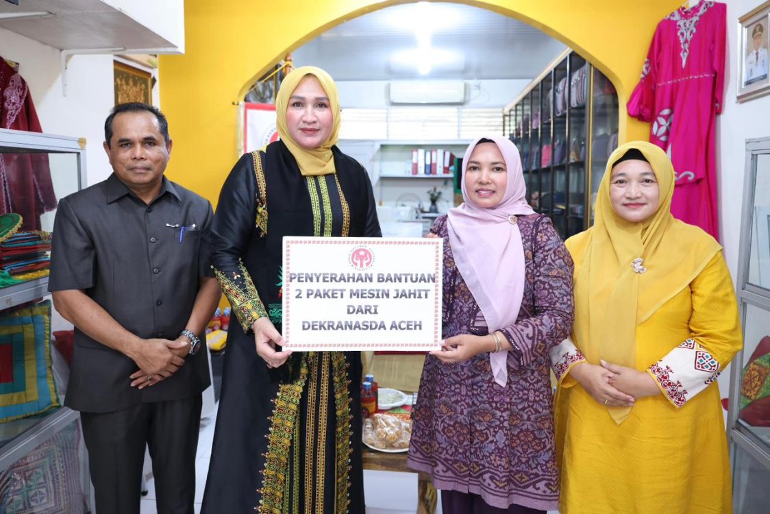 : Ketua Dekranasda Aceh Marlina Muzakir (Kak Na) menyerahkan bantuan 2 unit mesin jahit, 2 unit mesin obras, dan 5 mal Batik Cap kepada Dekranasda Aceh Utara saat berkunjung ke Gerai Dekranasda Kabupaten Aceh Utara, Selasa (1/9/2026).