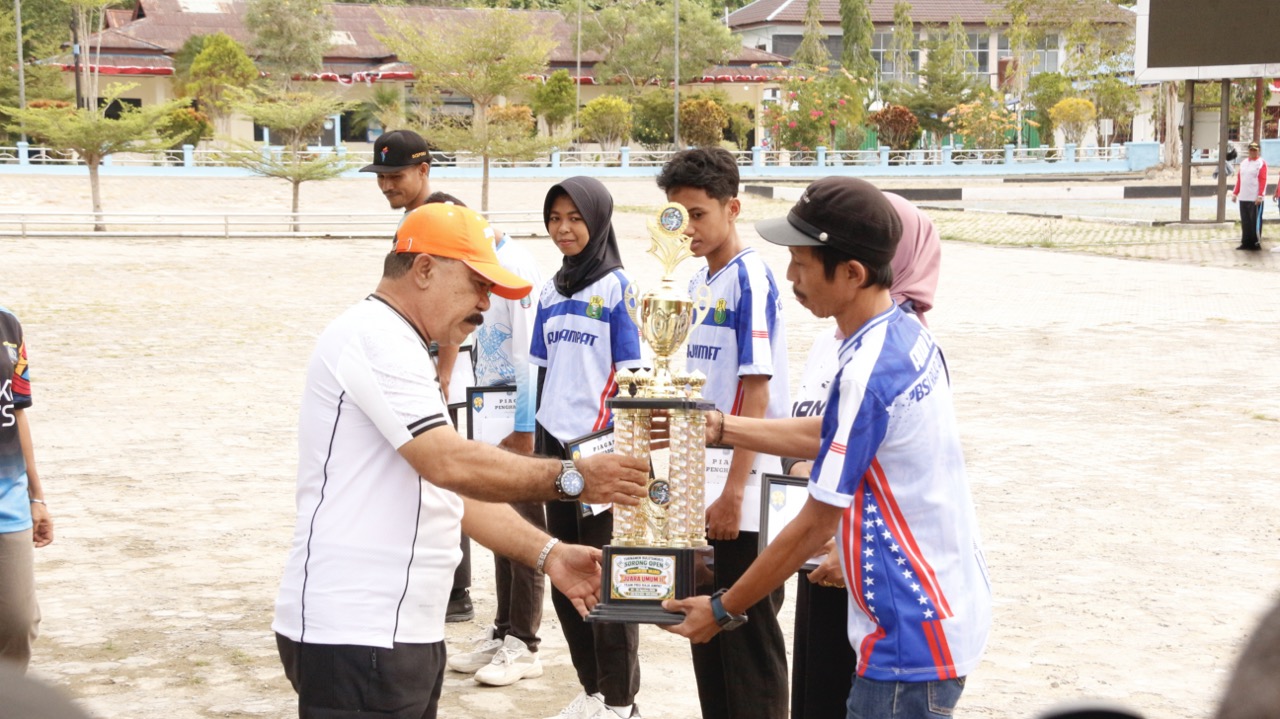 : Pemain peraih juara menyerahkan trofi kepada Pemerintah Kabupaten Raja Ampat pada peringatan Hari Olahraga Nasional (Haornas) 2026 di Lapangan Apel Kantor Bupati Raja Ampat, Waisai, Rabu (9/9/2026)/ (MC Raja Ampat/Liau).
