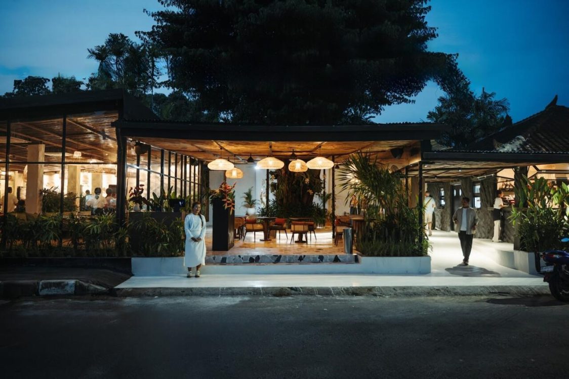 Seorang hostess menunggu tamu di pintu masuk Lava Gastrobar & Grill di Sanur