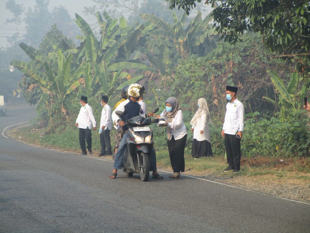 : Kepala Kantor Kementerian Agama Kabupaten Balangan, Nahdiyatul Husna, bersama jajaran turun langsung membagikan masker kepada pengendara yang melintas di depan Kantor Kemenag Balangan.._ Foto: Mc.Balangan