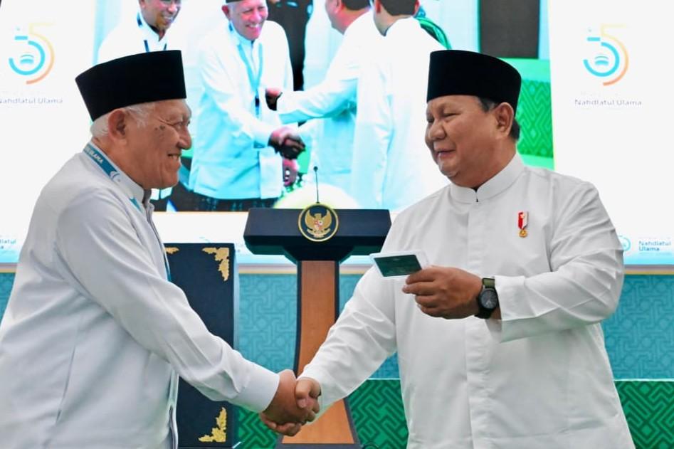 : Presiden Prabowo Subianto menerima kartu tanda anggota Nahdlatul Ulama (Kartanu) yang diserahkan oleh Rais Aam, Miftachul Akhyar pada Penutupan Muktamar ke-35 NU di Kabupaten Jombang, Provinsi Jawa Timur, Senin (31/8/2026). BPMI Setpres