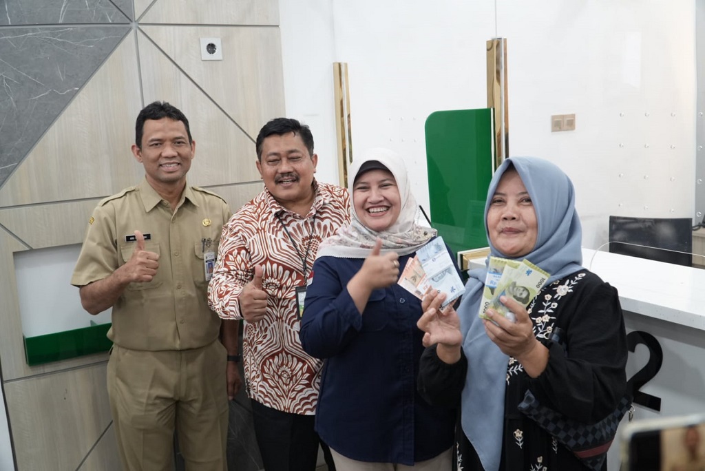: Salah satu warga Batang (kanan), menukar uang rusak di Kantor Pegadaian Batang, Kabupaten Batang.