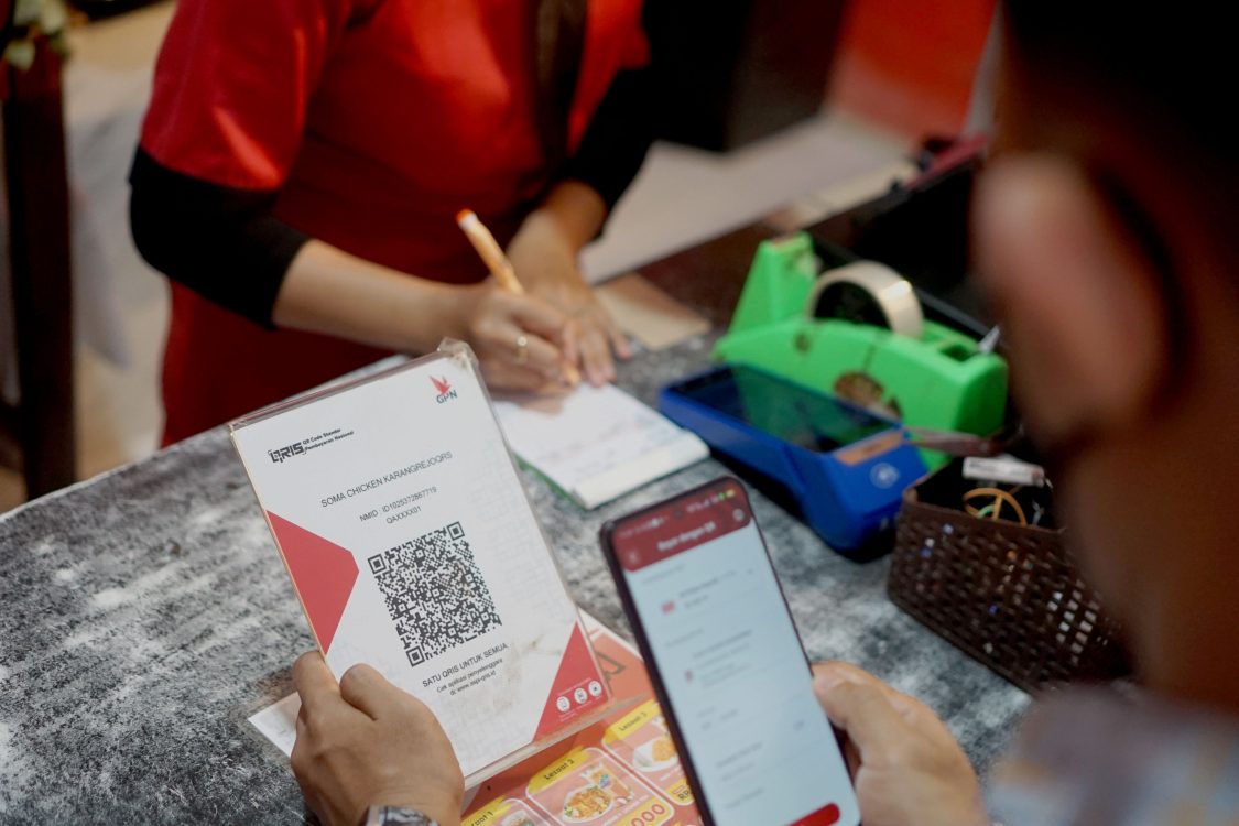 : Warga melakukan pembayaran transaksi digital melalui QRIS (Quick Response Code Indonesia Standard) di salah satu merchant CIMB Niaga di Tulungagung , Jawa Timur, Kamis (21/8/2025). Bank Indonesia melaporkan volume transaksi pembayaran digital melalui QRIS hingga akhir Juli 2025 terus tumbuh pesat sebesar 162,77 persen (yoy) seiring peningkatan jumlah pengguna dan merchant. (ANTARA FOTO/Destyan Sujarwoko/nz)
