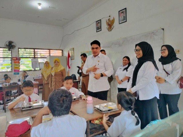 : Anggota Komisi E DPRD Jatim, Cahyo Haryo Prakoso saat bersama kepala SPPG Kepala SPPG Pelabuhan Tanjung Perak, Ichda Afifatul Rahma meninjau menu Makan Bergizi Gratis (MBG) SD N Perak Utara III/60 Surabaya. - Foto: Mc.Jatim