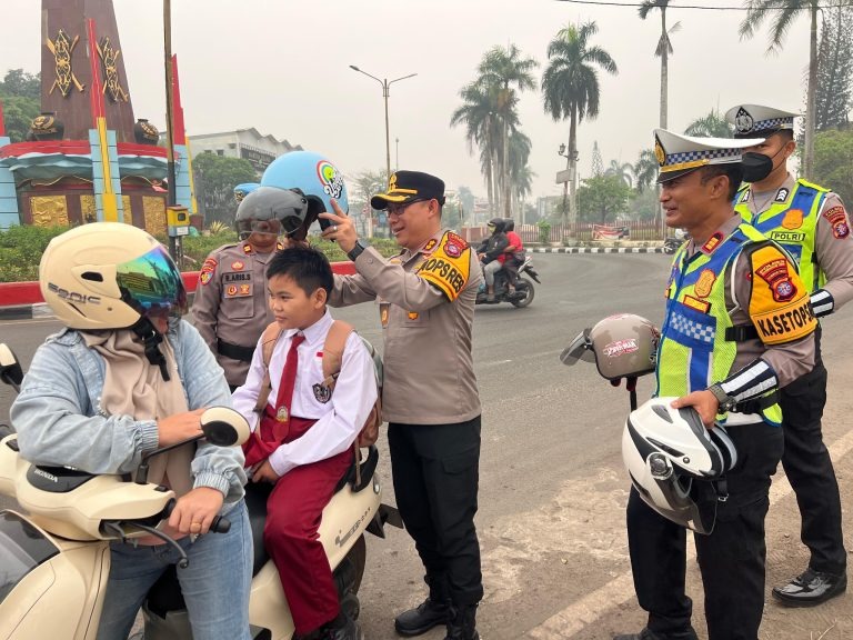 Kapolres Kotim Laksanakan Pengaturan Lalu Lintas serta Bagikan Helm kepada Masyarakat