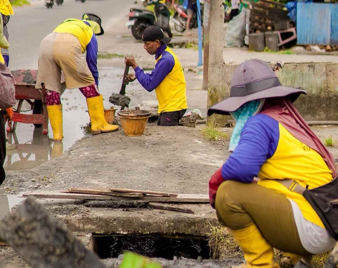 : Pasukan kuning Dinas PUPR Pekanbaru tengah melakukan normalisasi drainase atau saluran pembuangan air.- Foto: Mc.Pekanbaru