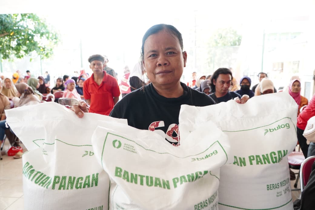 : Seorang Ibu yang tengah menerima bantuan pangan Beras dari Badan Pangan Nasional (Bapanas) dan Perum Bulog. (Foto : Humas Bapanas)