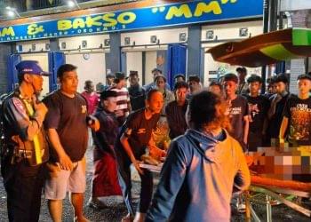 Petugas kepolisian bersama warga membantu proses evakuasi korban kecelakaan lalu lintas ke ambulans di kawasan Srimartani, Piyungan, Bantul, Minggu (11/1/2026) malam.