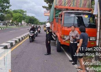Petugas kepolisian melakukan pengamanan dan pengaturan arus lalu lintas di lokasi kecelakaan yang melibatkan truk dan sepeda motor di Jalan Ring Road Selatan, Tamantirto, Kecamatan Kasihan, Kabupaten Bantul, Minggu (11/1/2026) sore.