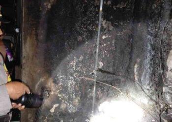 Petugas kepolisian melakukan pengecekan di lokasi kebakaran pabrik tahu di Dusun Nitipuran, Kasihan, Bantul, dengan menyoroti bagian dinding dan instalasi yang hangus terbakar guna memastikan sumber api dan tingkat kerusakan pascakejadian.